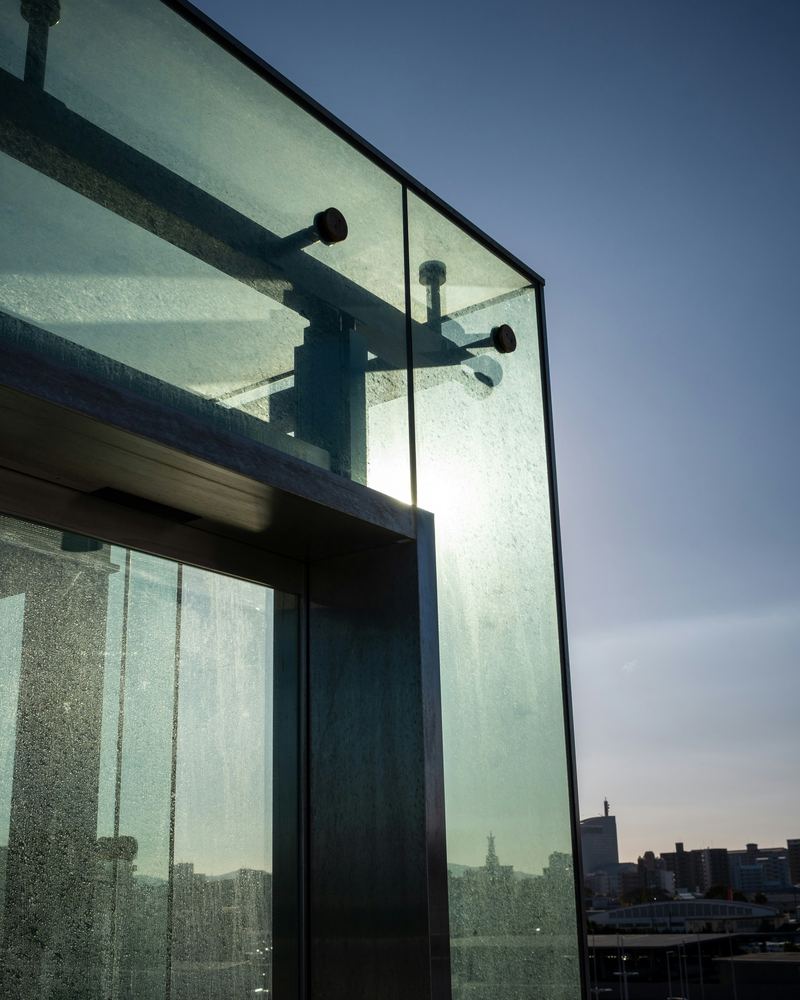 Spider fitting glass facade detail at sunset